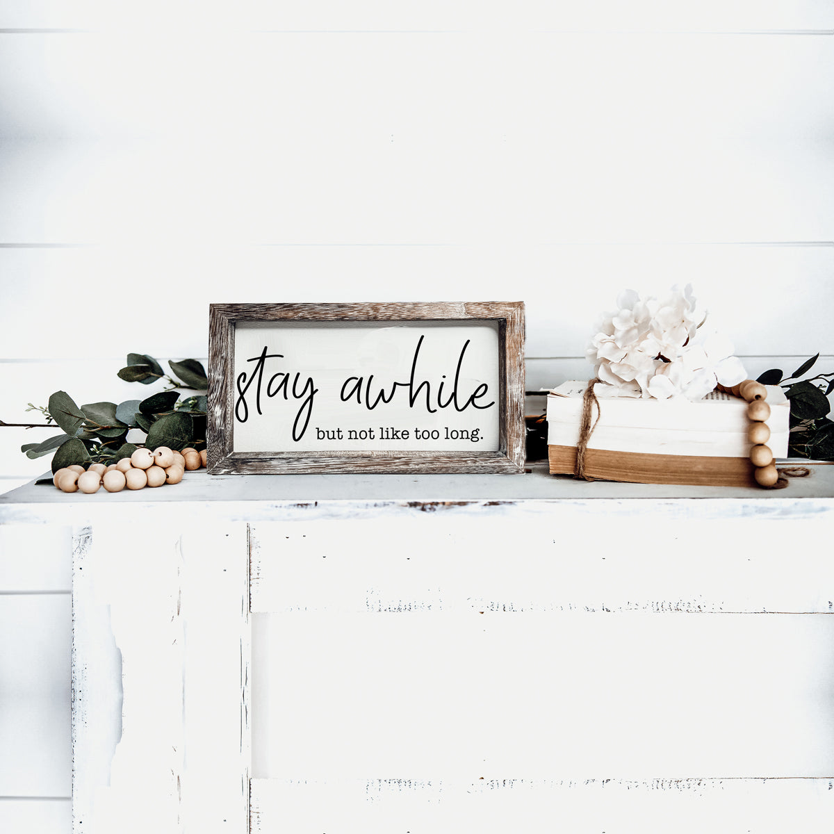 Stay Awhile Sign made of Paulownia wood featuring a humorous message, designed for wall hanging or standing display.