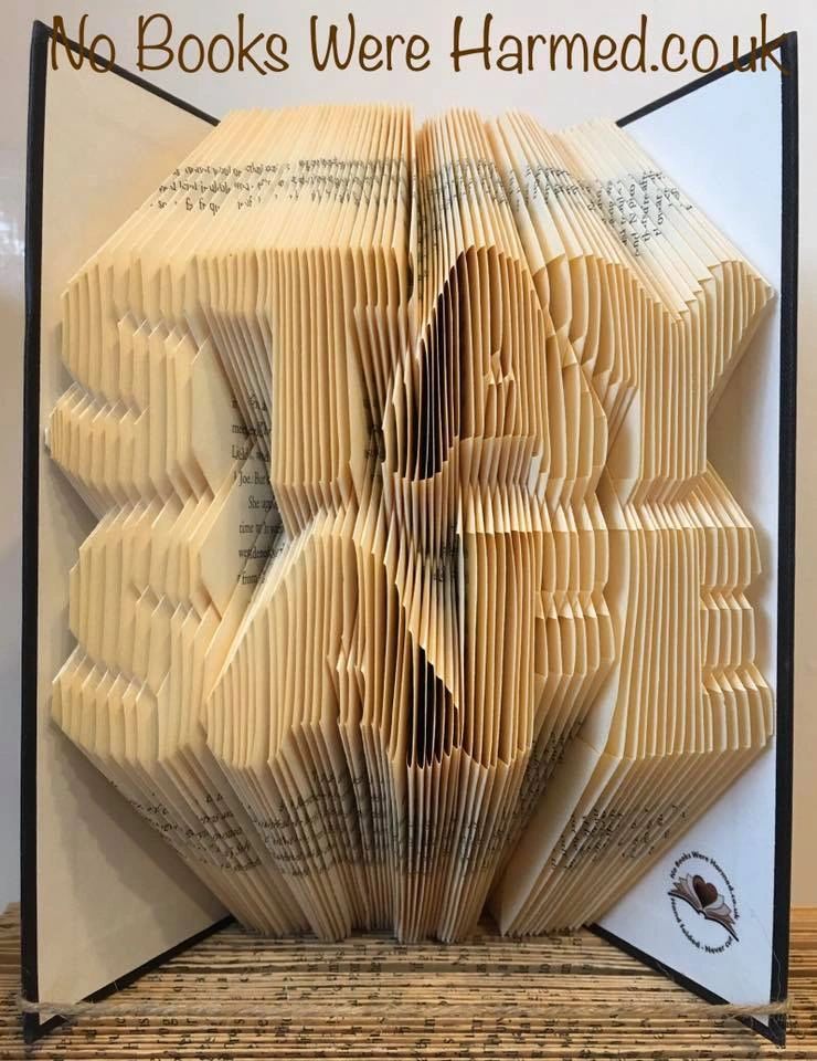 Unique hand-folded book art piece made from vintage books, showcasing intricate folds and natural colors.