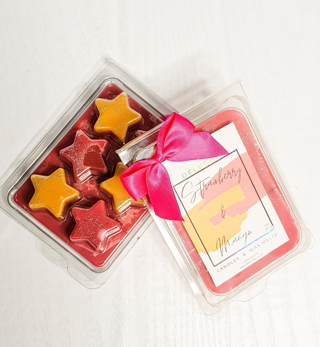 Strawberry and Mango wax melts in star, heart, and cube shapes, showcasing vibrant colors and delightful fragrances.