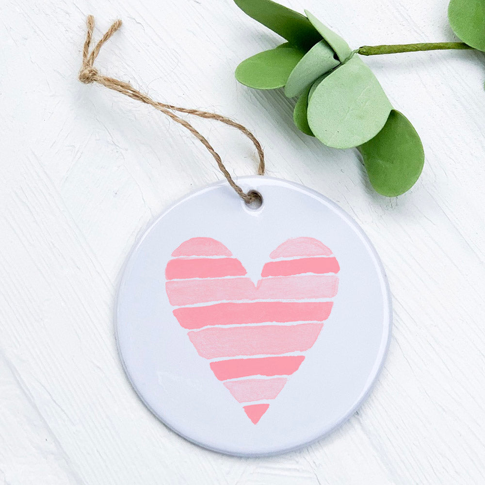 A beautifully crafted porcelain ornament featuring a striped heart design, showcasing vibrant colors and a glossy finish.