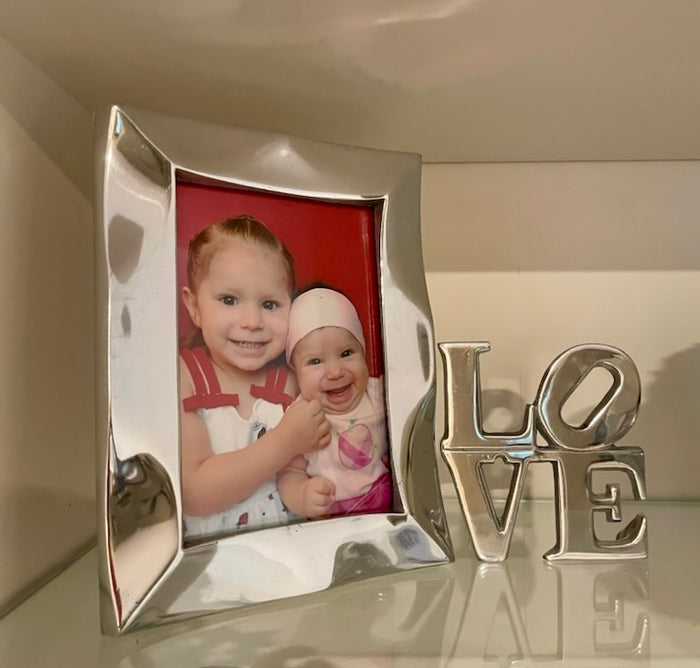 Stylish Picture Frame made of recycled aluminum, featuring a minimalist design with clean lines and a wood holder for vertical or horizontal display.