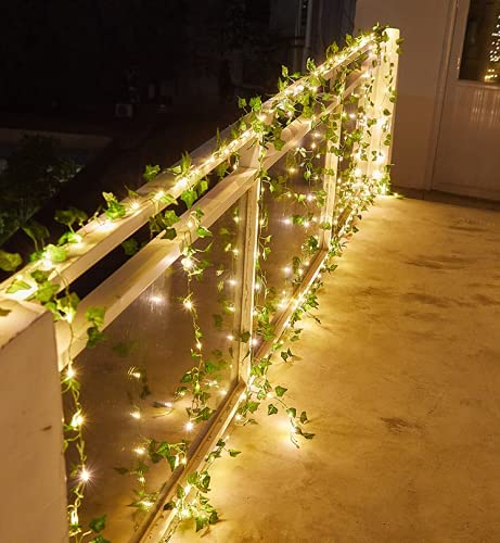 A 32ft long string light garland with 100 warm white LEDs and artificial grape leaves, elegantly displayed in a cozy setting.