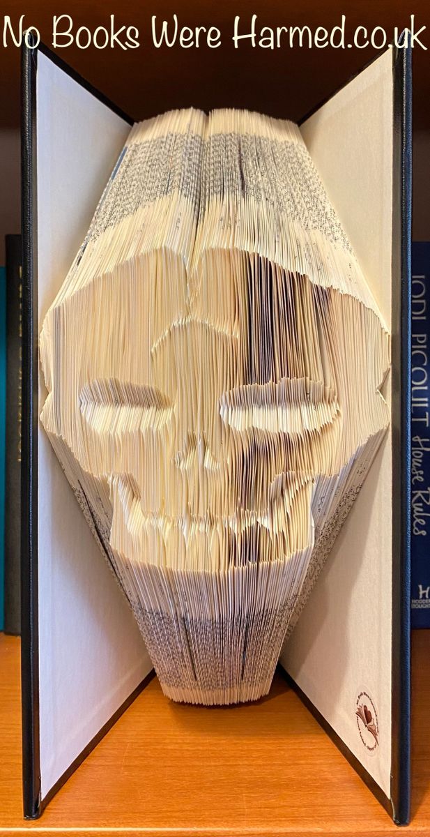 A hand-folded book art piece featuring a stag's head design, crafted from vintage Encyclopedia Britannica pages with a classic black padded cover.