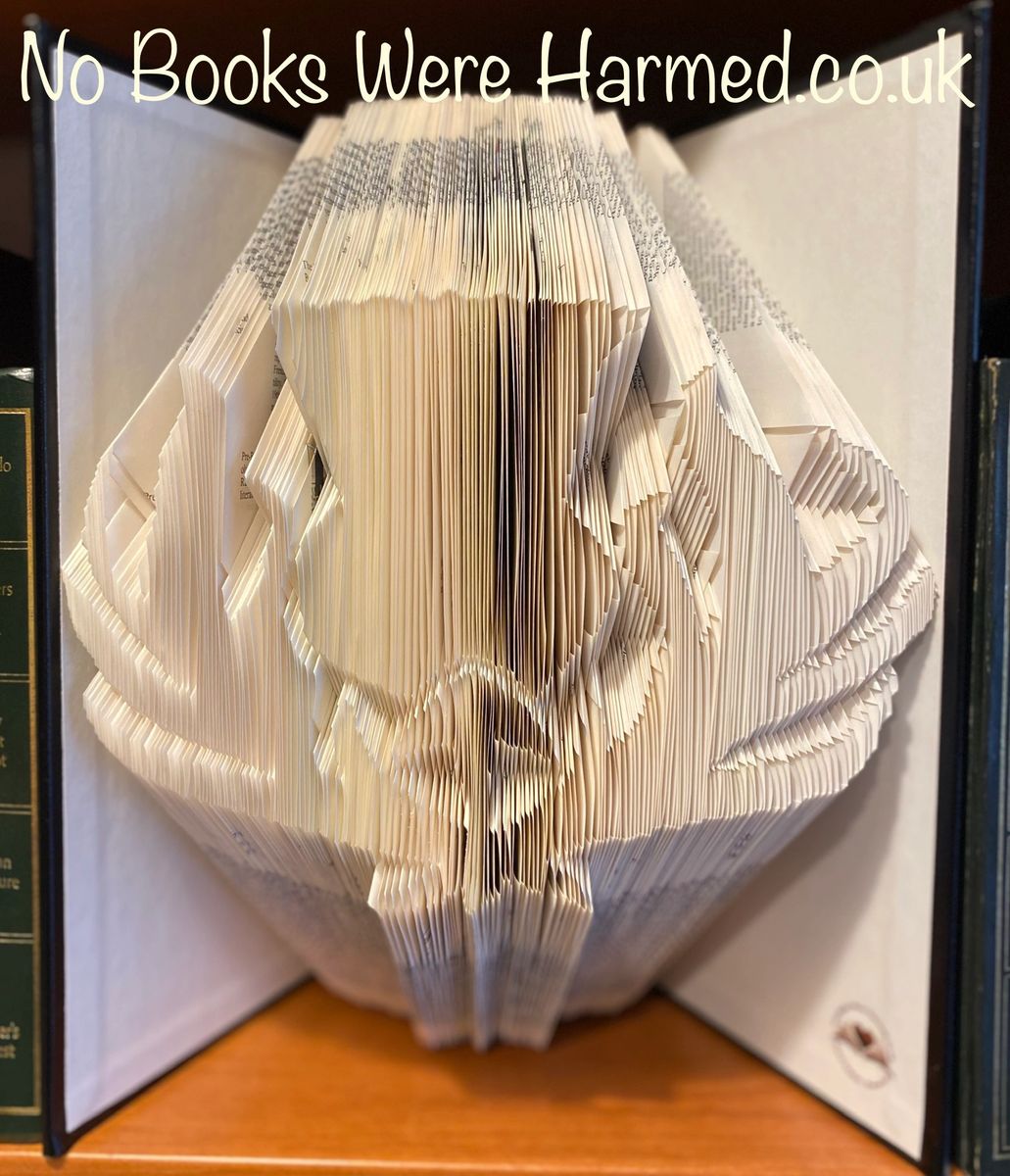 Hand-folded book art featuring a Scottish thistle design, crafted from vintage Encyclopedia pages with a classic black padded cover.