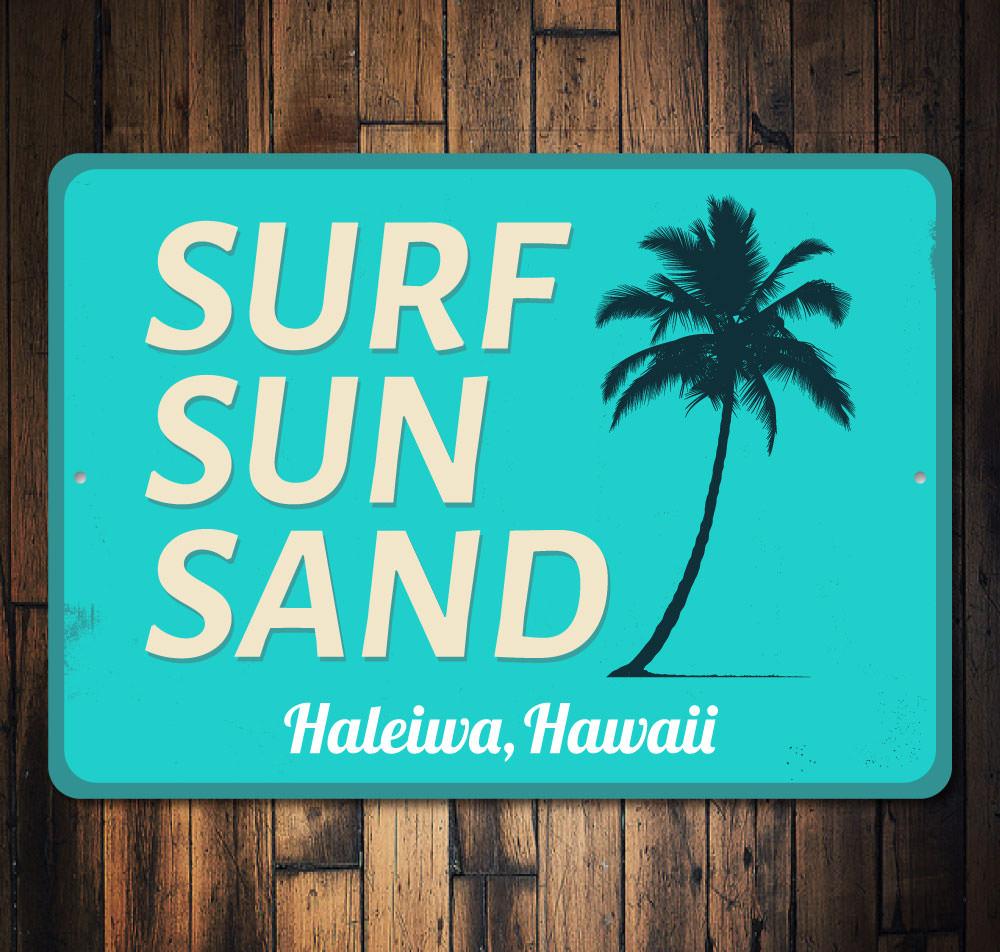 A decorative Surf Sun Sand Sign made of aluminum, featuring vibrant colors and a beach-themed design, perfect for coastal decor.