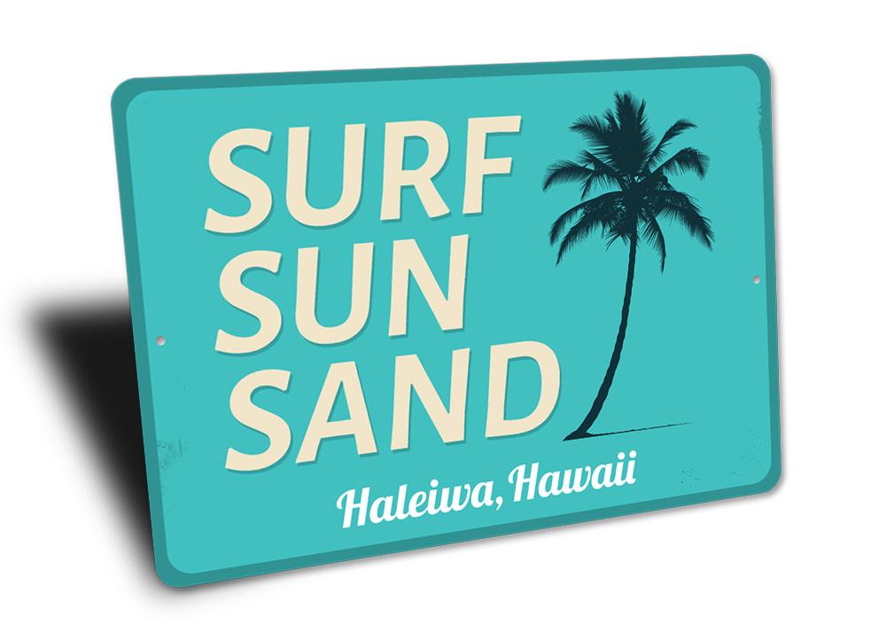 A decorative Surf Sun Sand Sign made of aluminum, featuring vibrant colors and a beach-themed design, perfect for coastal decor.