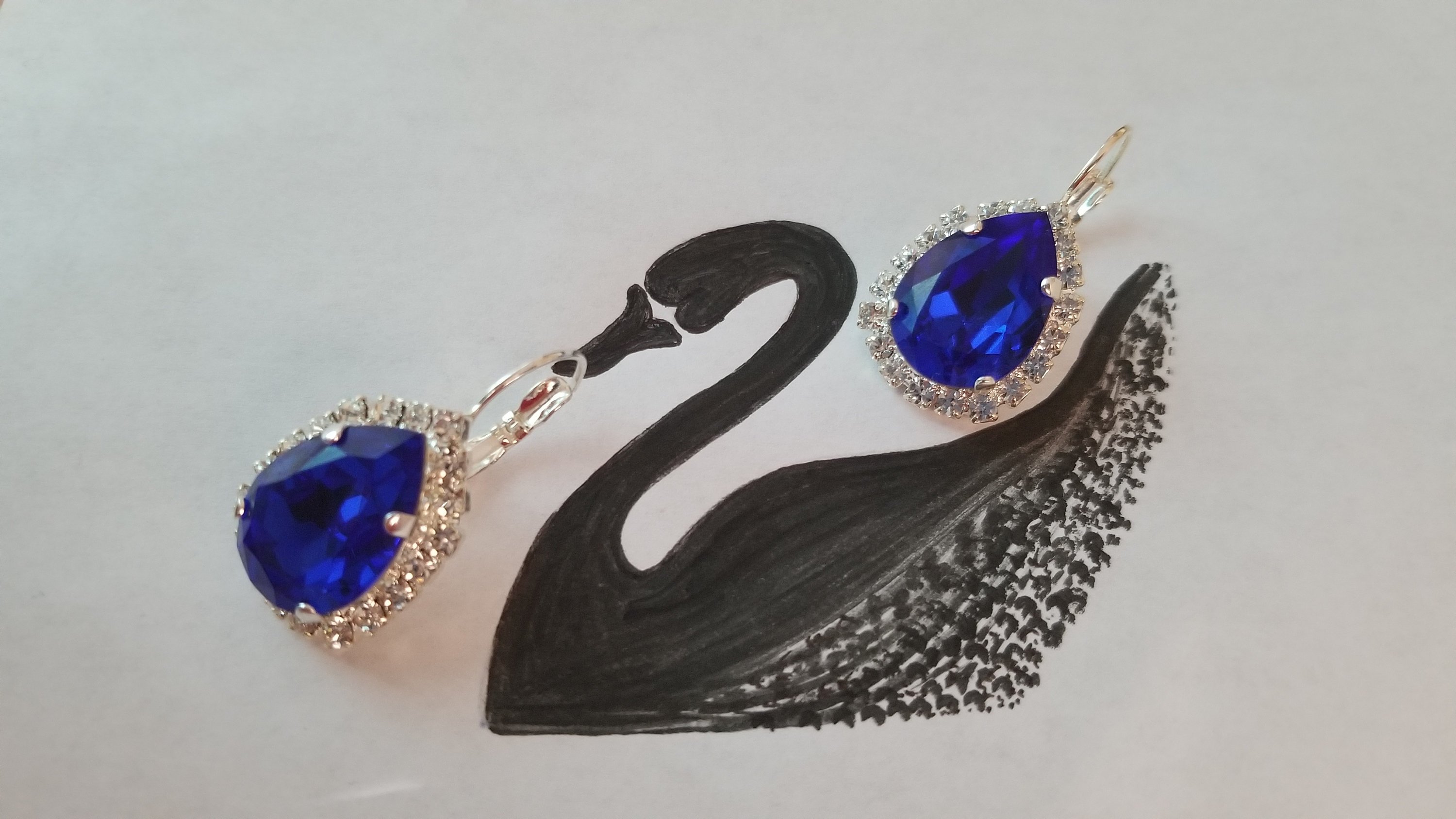 Elegant Swarovski Crystal Pear Shaped Statement Earrings featuring vibrant colored crystals in gold, silver, and hematite settings.