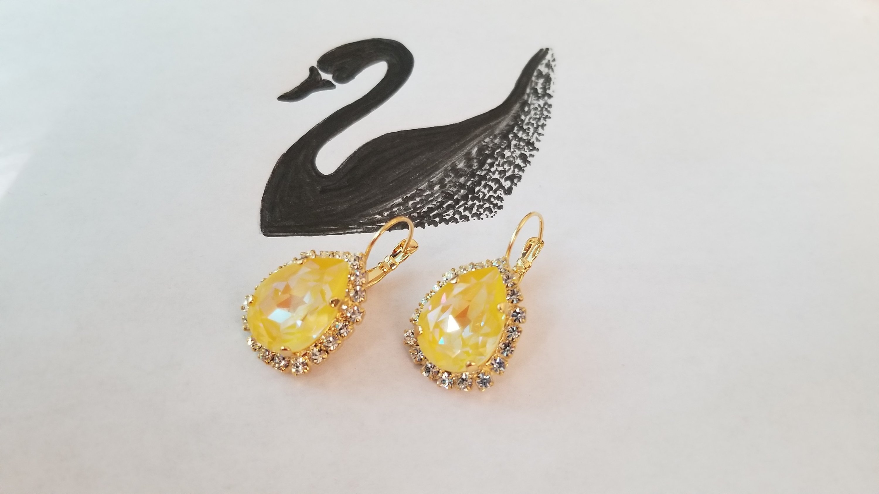 Elegant Swarovski Crystal Pear Shaped Statement Earrings featuring vibrant colored crystals in gold, silver, and hematite settings.