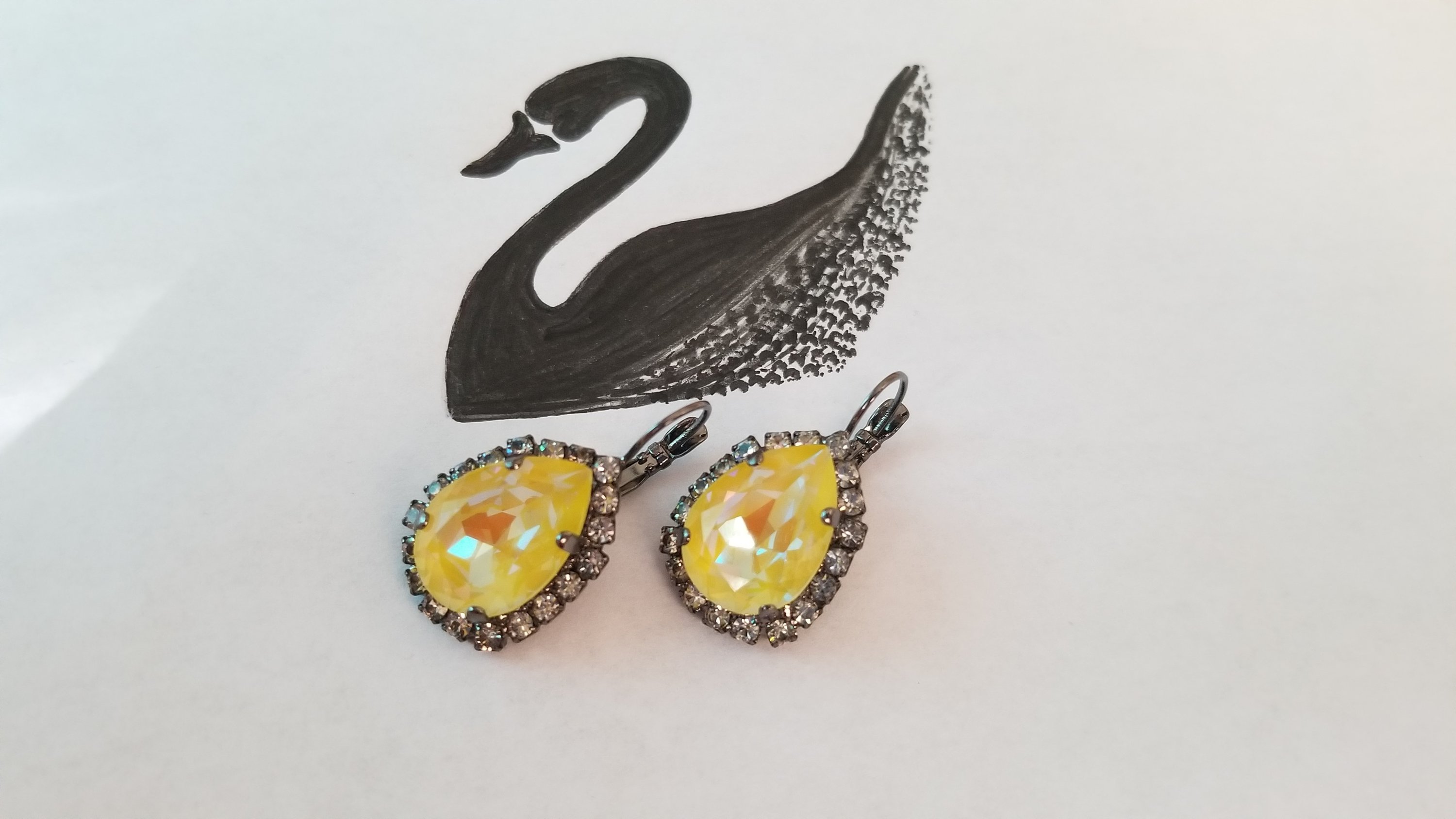 Elegant Swarovski Crystal Pear Shaped Statement Earrings featuring vibrant colored crystals in gold, silver, and hematite settings.