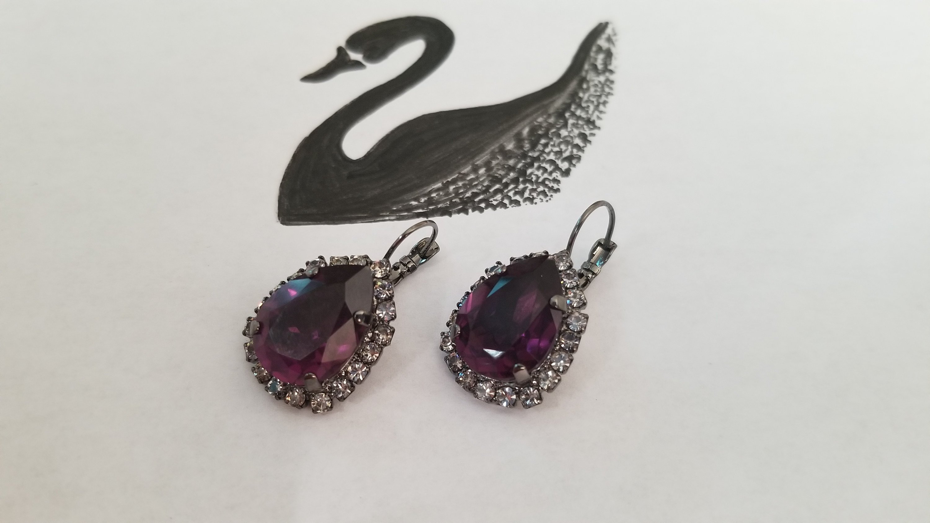 Elegant Swarovski Crystal Pear Shaped Statement Earrings featuring vibrant colored crystals in gold, silver, and hematite settings.