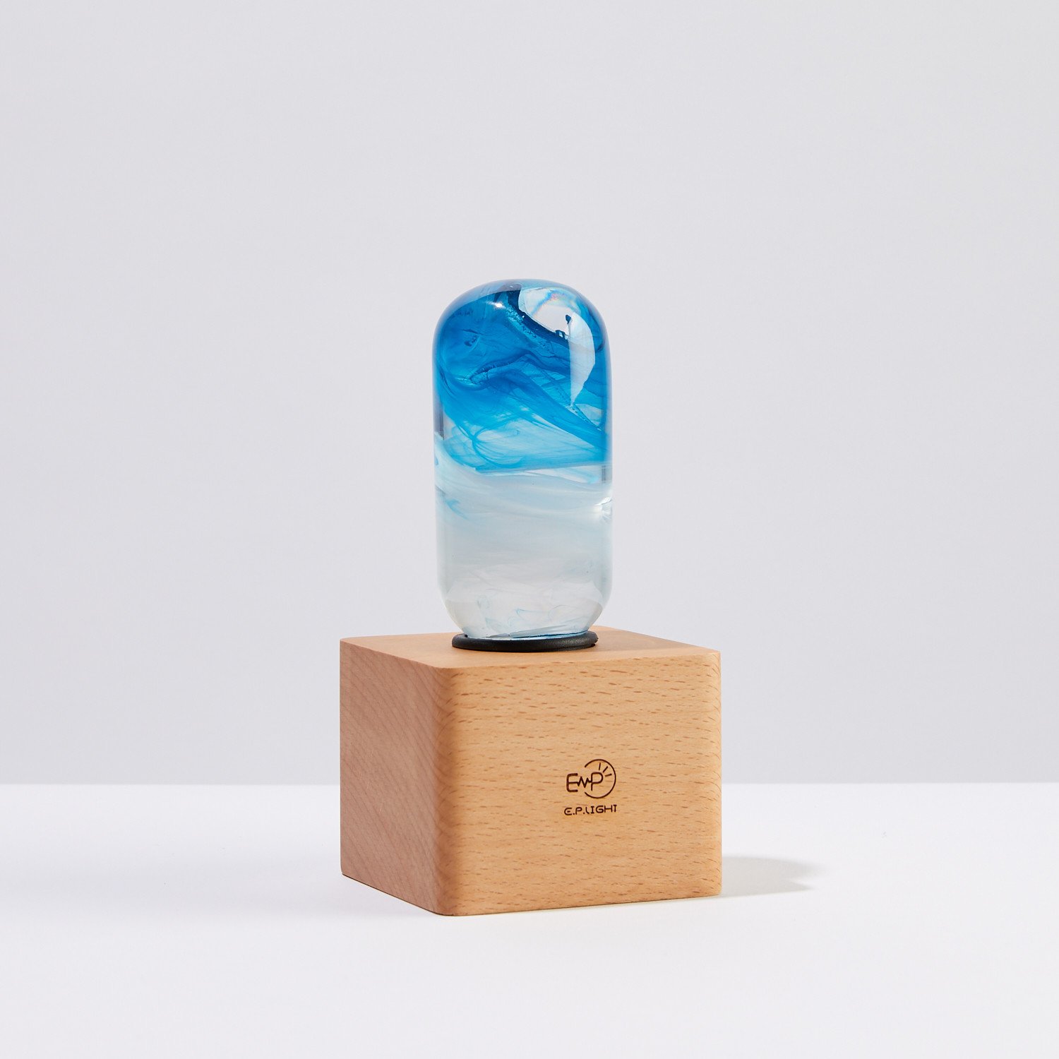 A stylish blue table lamp made from eco-friendly resin and beech wood, featuring an LED bulb and a modern design.