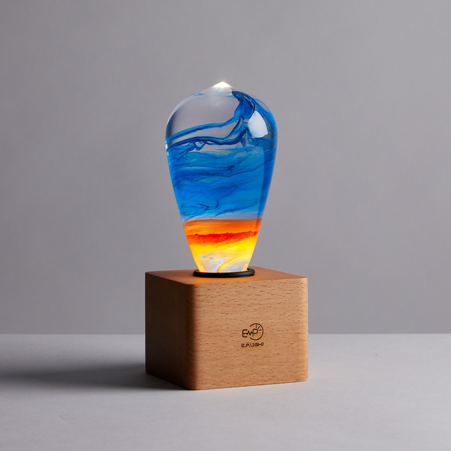 A beautifully handcrafted Fire Table Lamp made of eco-friendly resin and beech wood, featuring a vibrant mixed color design.