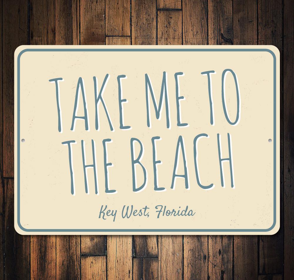 A decorative 'Take Me To The Beach' sign made of high-quality aluminum, featuring beach-themed graphics and customizable text options.