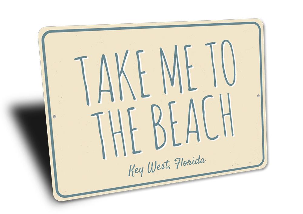 A decorative 'Take Me To The Beach' sign made of high-quality aluminum, featuring beach-themed graphics and customizable text options.