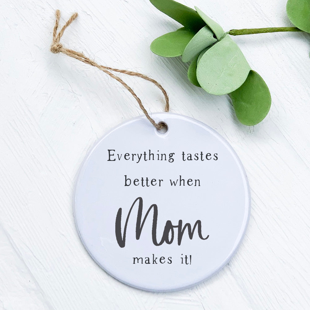 A beautifully crafted porcelain ornament featuring the design 'Tastes Better Mom', showcasing vibrant colors and a smooth gloss finish.