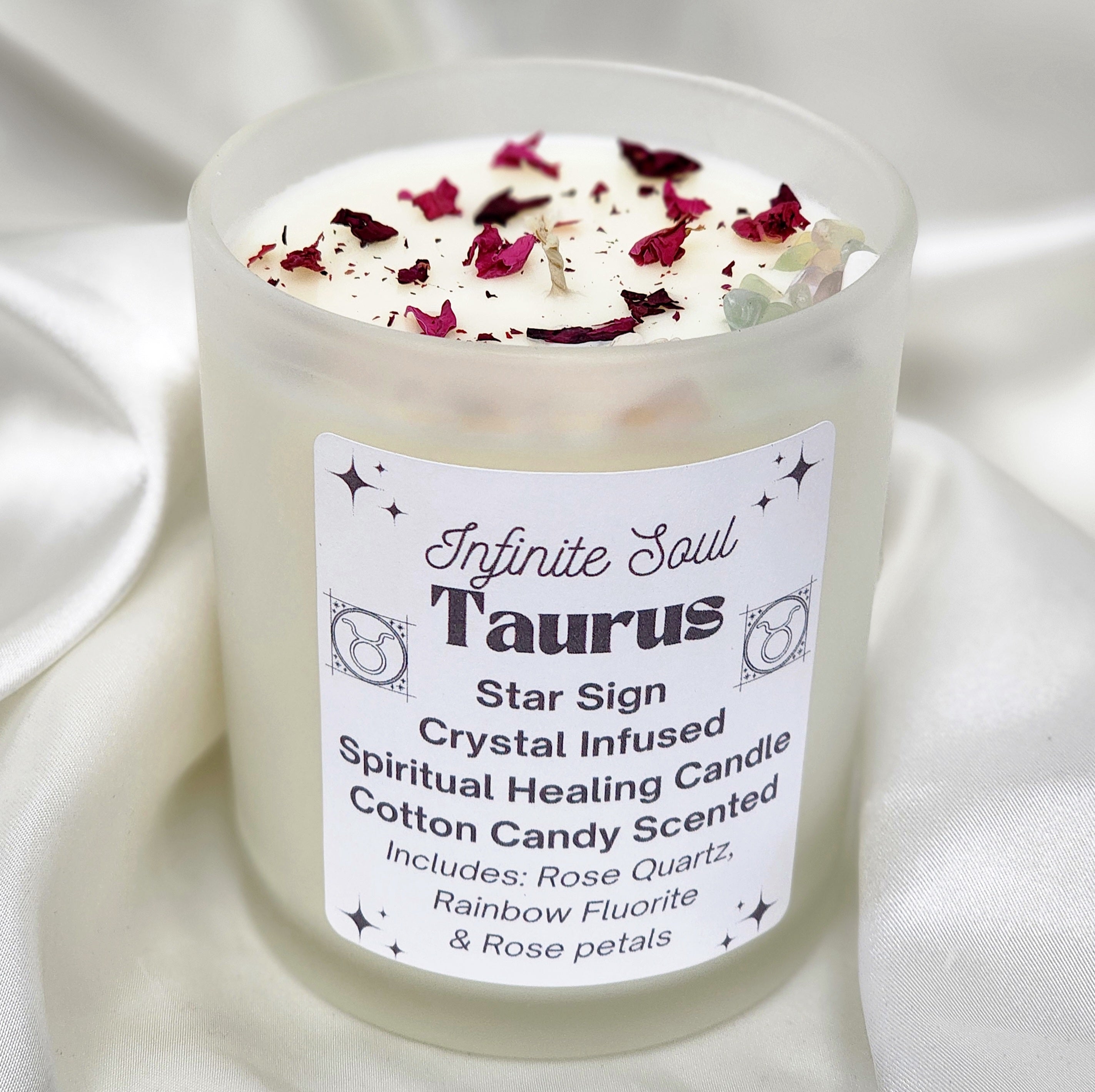 Taurus Star Sign Crystal Infused Candle with cotton candy scent, featuring rose quartz and rainbow fluorite crystals, adorned with dried rose petals.