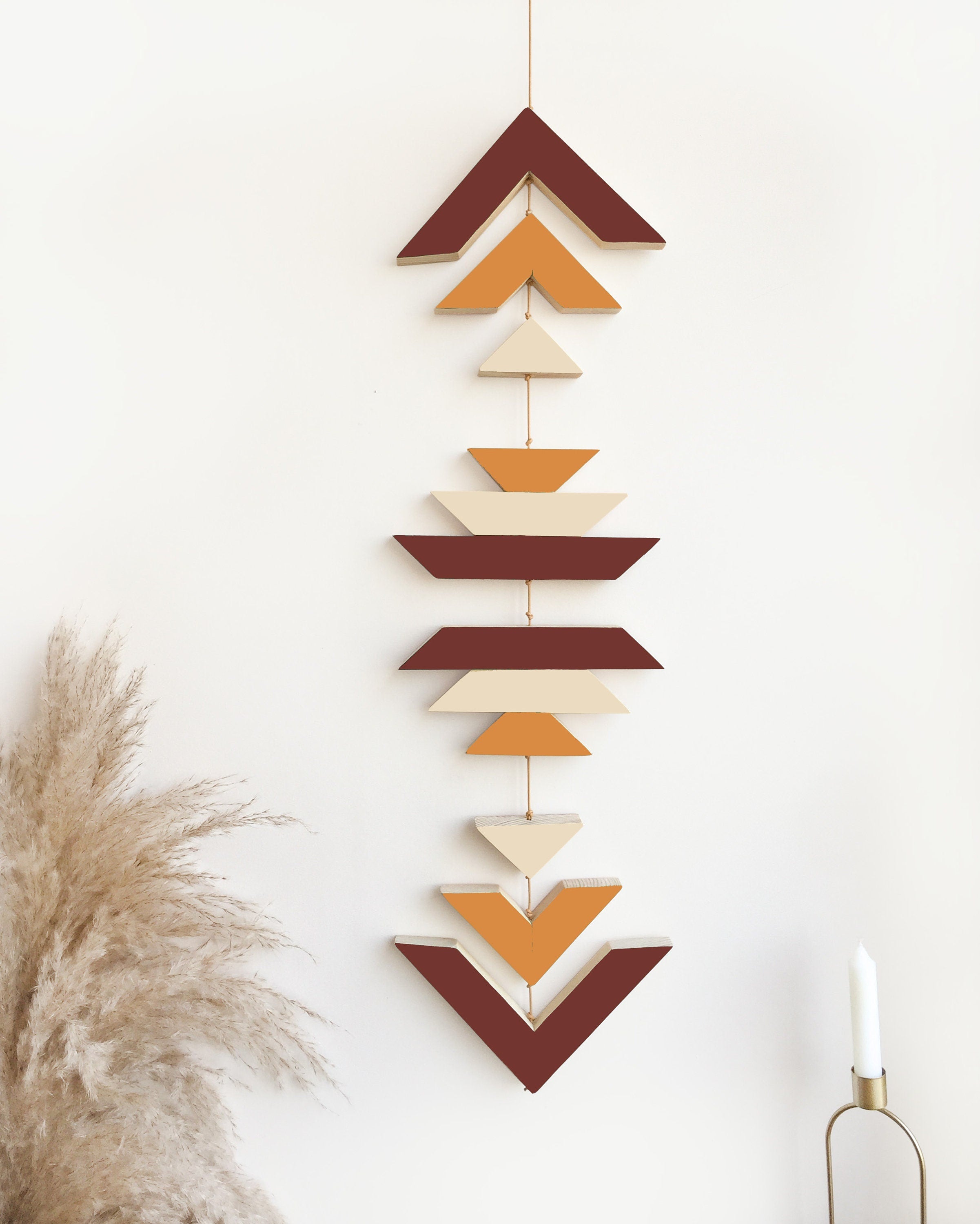 A beautiful Terra Wood Wall Hanging featuring earthy tones, perfect for boho decor, displayed against a white wall.