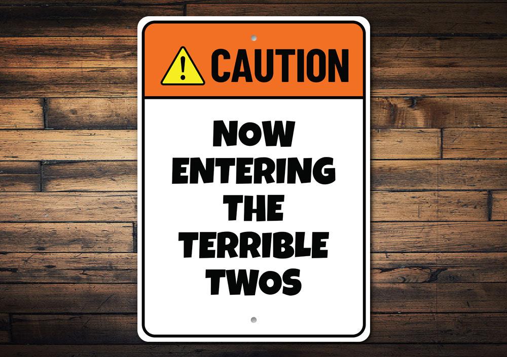 Terrible Twos Sign made of aluminum, featuring humorous text and vibrant colors, perfect for wall decor in playrooms or nurseries.