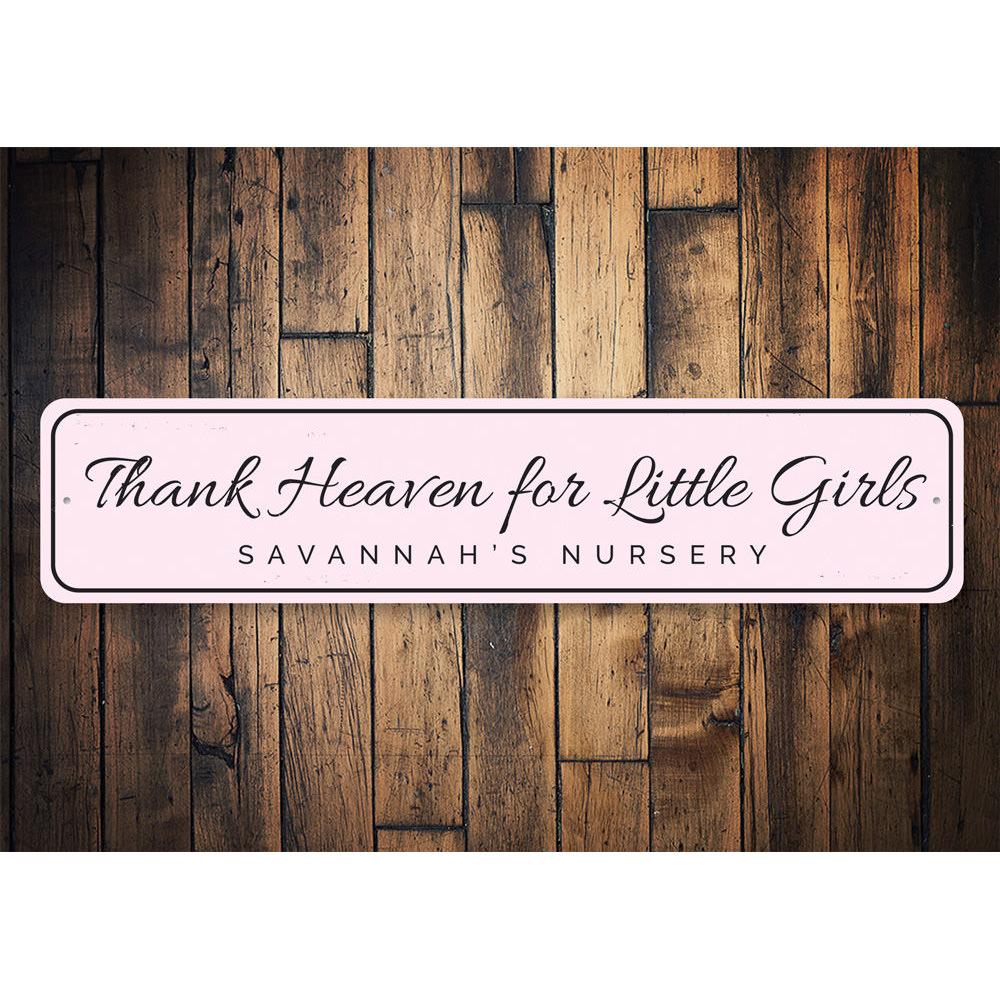 Decorative 'Thank Heaven for Little Girls' sign made of aluminum, featuring a charming design suitable for children's rooms.