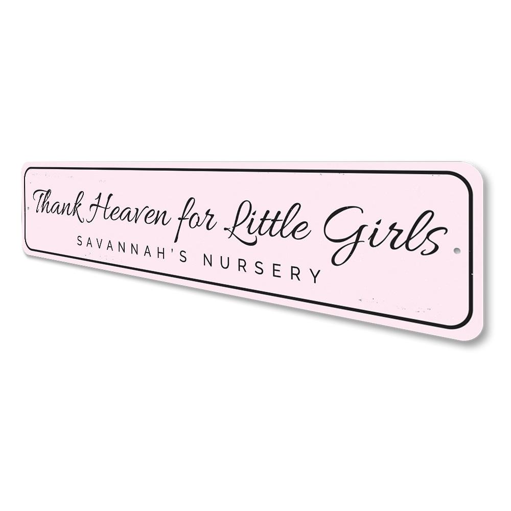 Decorative 'Thank Heaven for Little Girls' sign made of aluminum, featuring a charming design suitable for children's rooms.