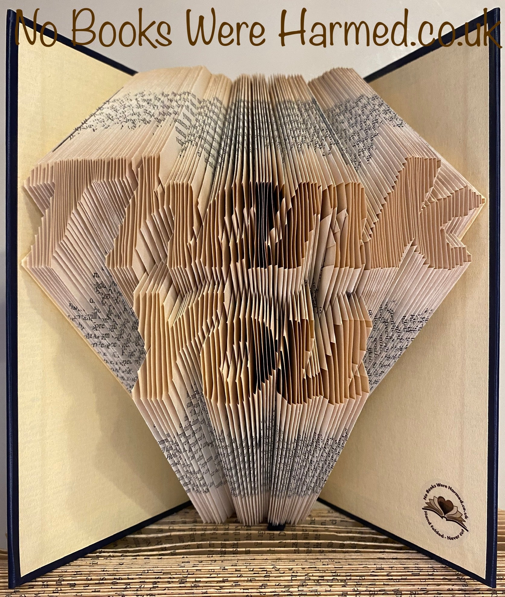 Hand-folded book art piece made from vintage pages, showcasing unique designs and intricate craftsmanship.