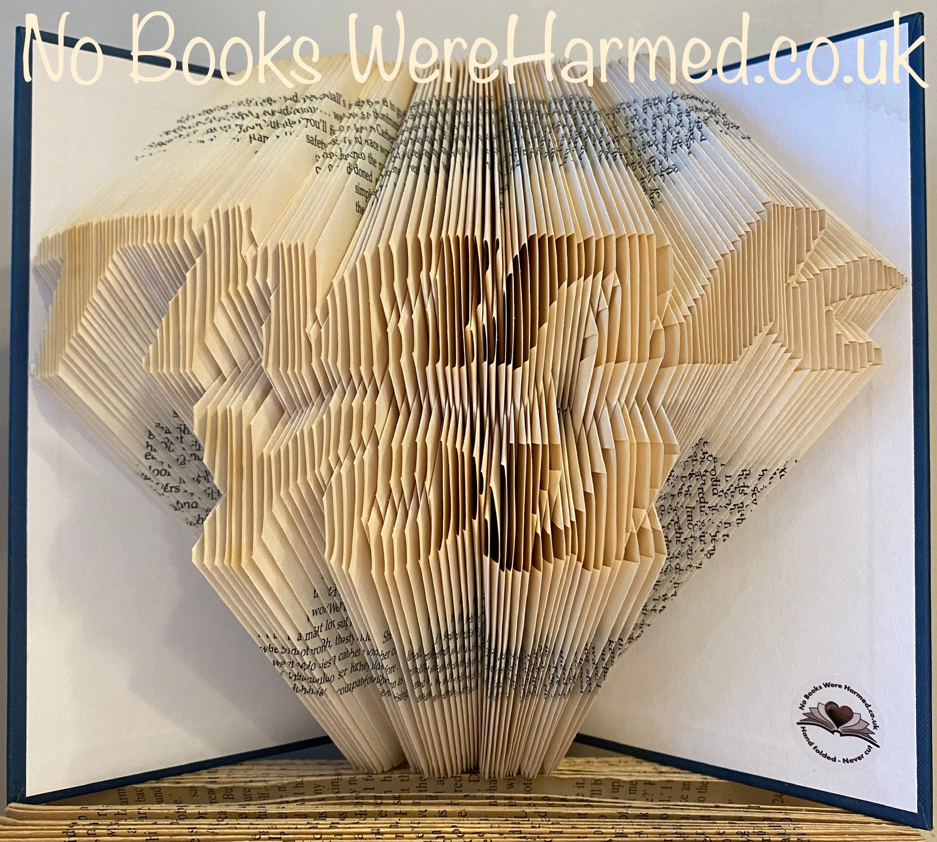 Hand-folded book art piece made from vintage pages, showcasing unique designs and intricate craftsmanship.