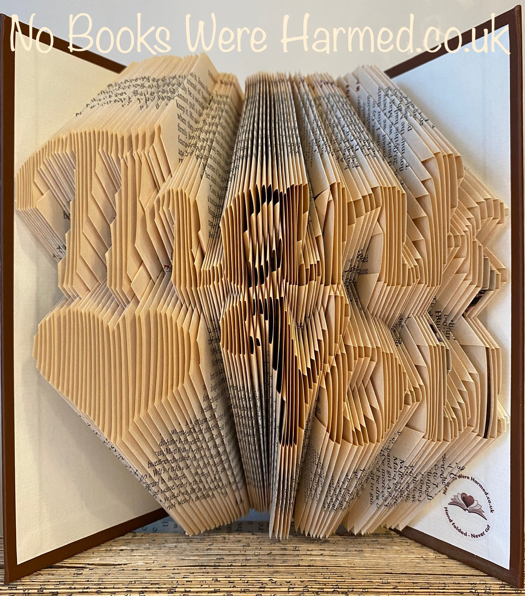 Handcrafted 'Thank You' art piece featuring a love heart, made from vintage book pages, showcasing unique folds and textures.