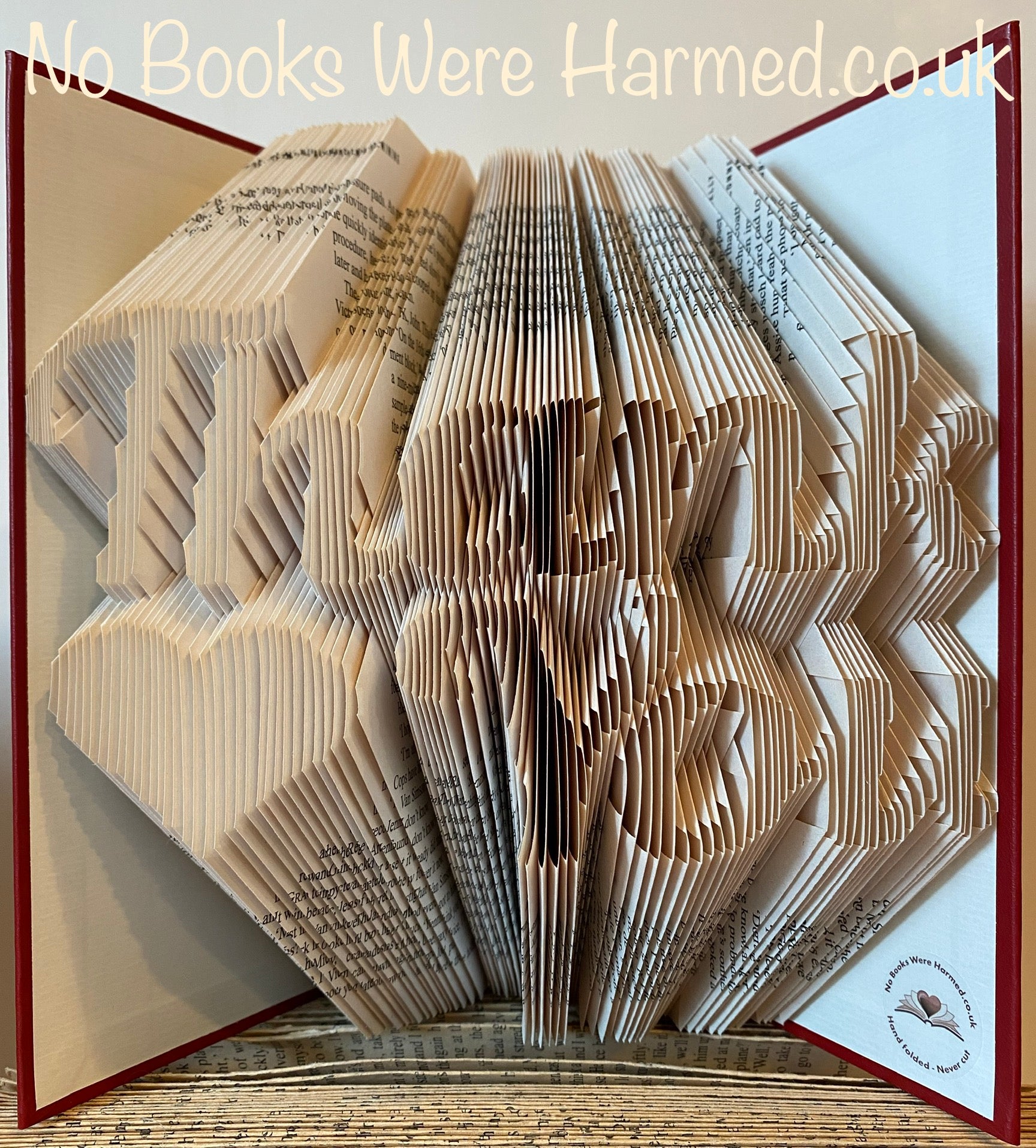 Handcrafted 'Thank You' art piece featuring a love heart, made from vintage book pages, showcasing unique folds and textures.