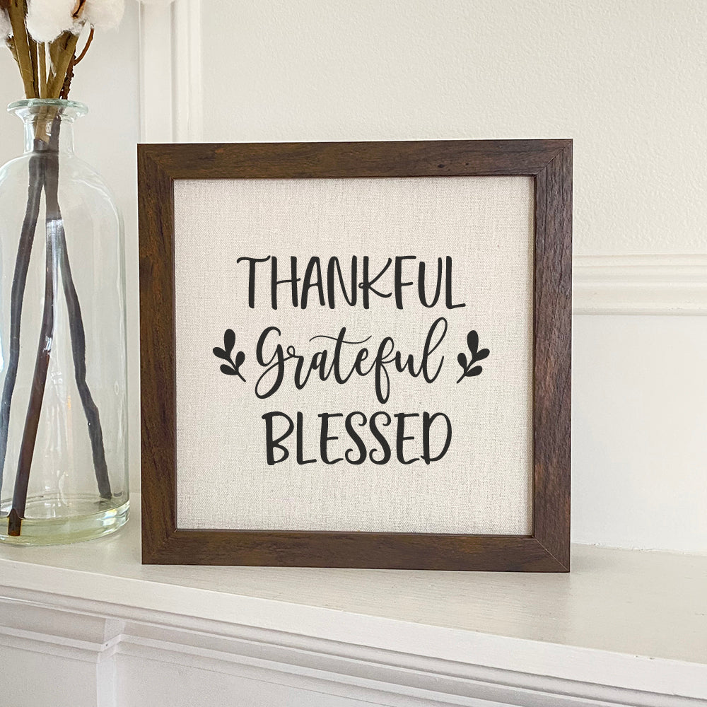 Thankful Grateful Blessed framed sign with a stylish wood frame and linen-look background, perfect for home decor.