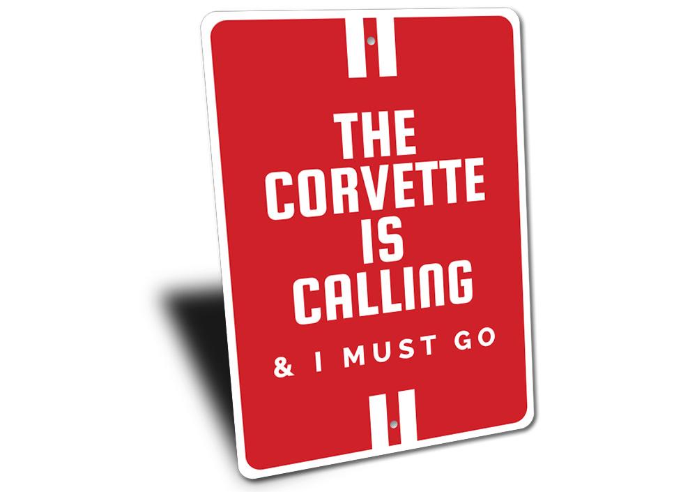 A vibrant aluminum sign featuring the text 'The Corvette Is Calling', showcasing a classic Corvette design, perfect for car enthusiasts.