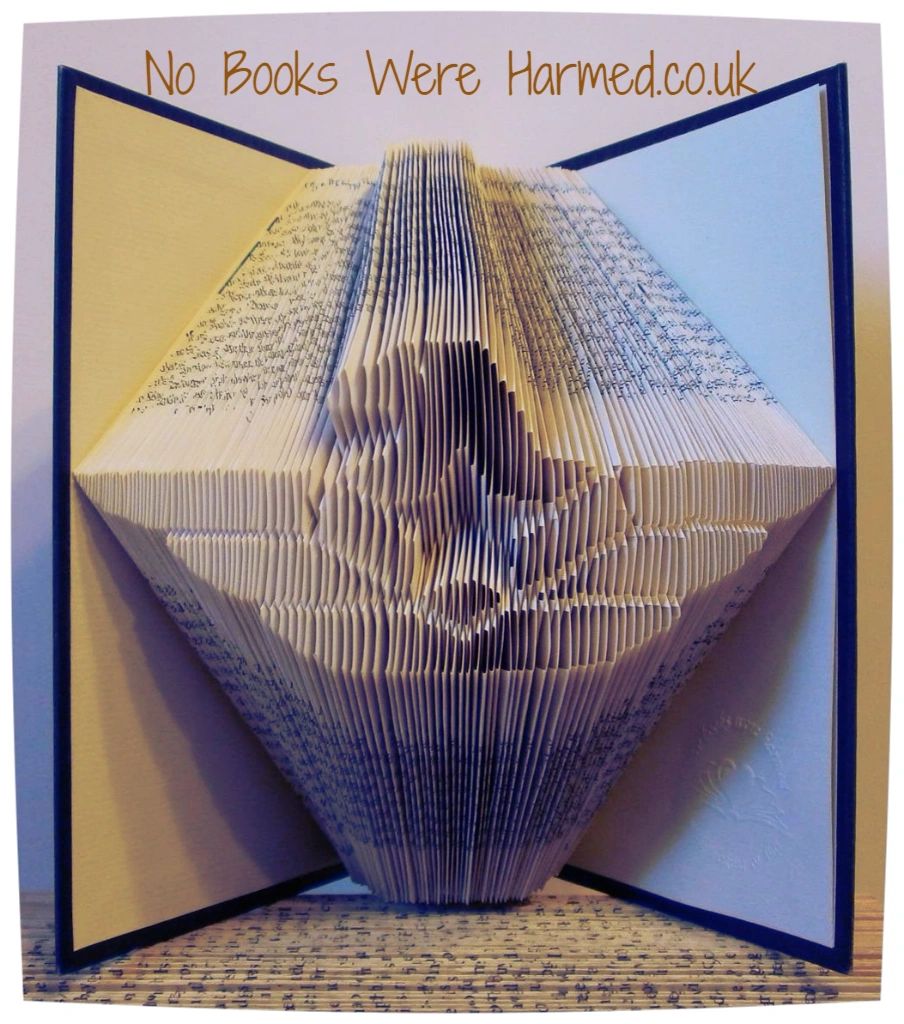 Handcrafted book art featuring a majestic eagle, intricately folded from vintage book pages, showcasing unique colors and textures.