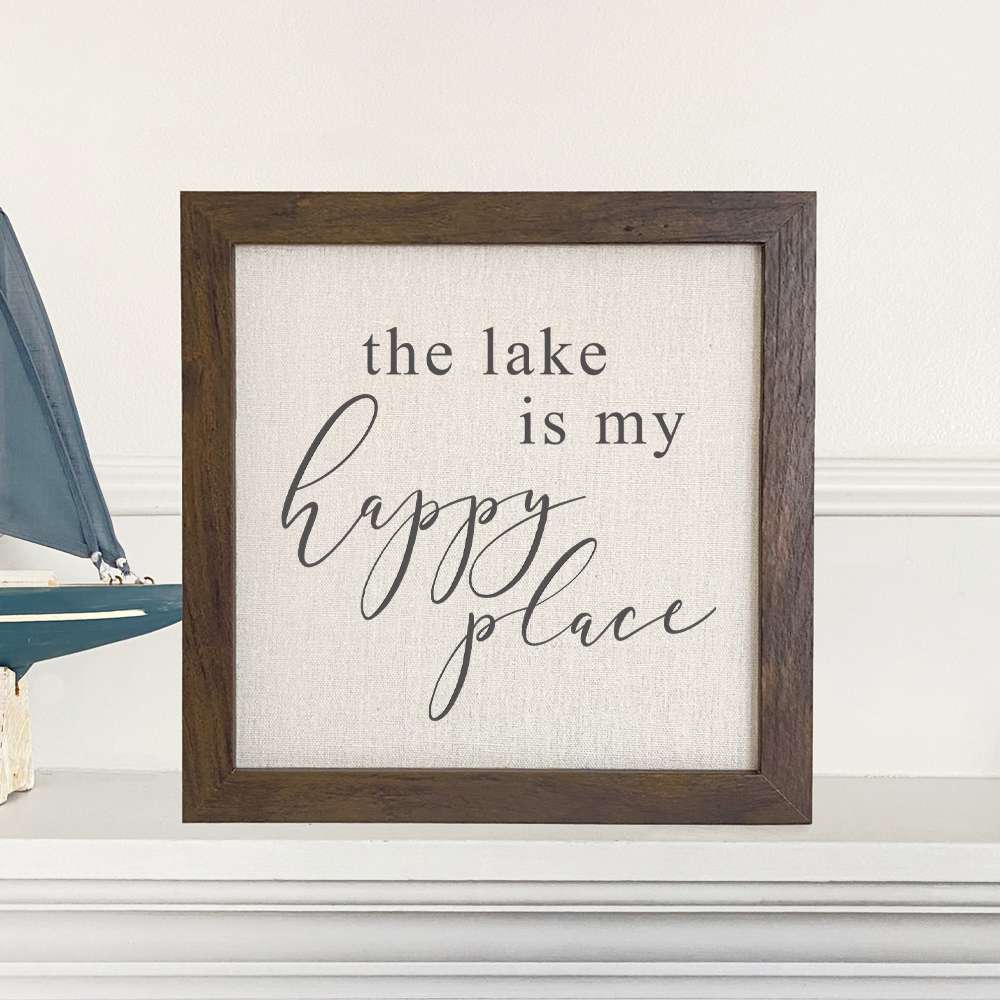 Framed sign reading 'The Lake is My Happy Place' with a stylish wood frame and linen-look background.