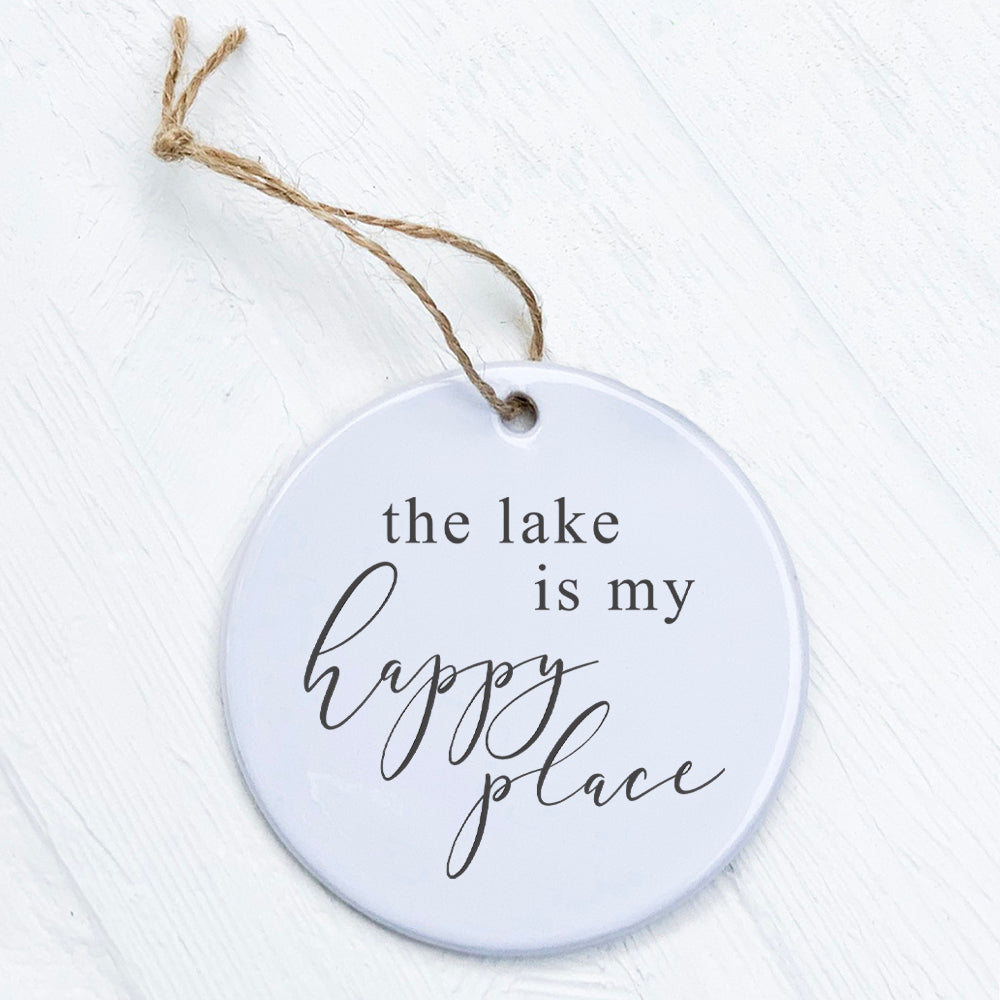 A beautifully crafted porcelain ornament featuring the phrase 'The Lake is My Happy Place', showcasing vibrant colors and a smooth finish.