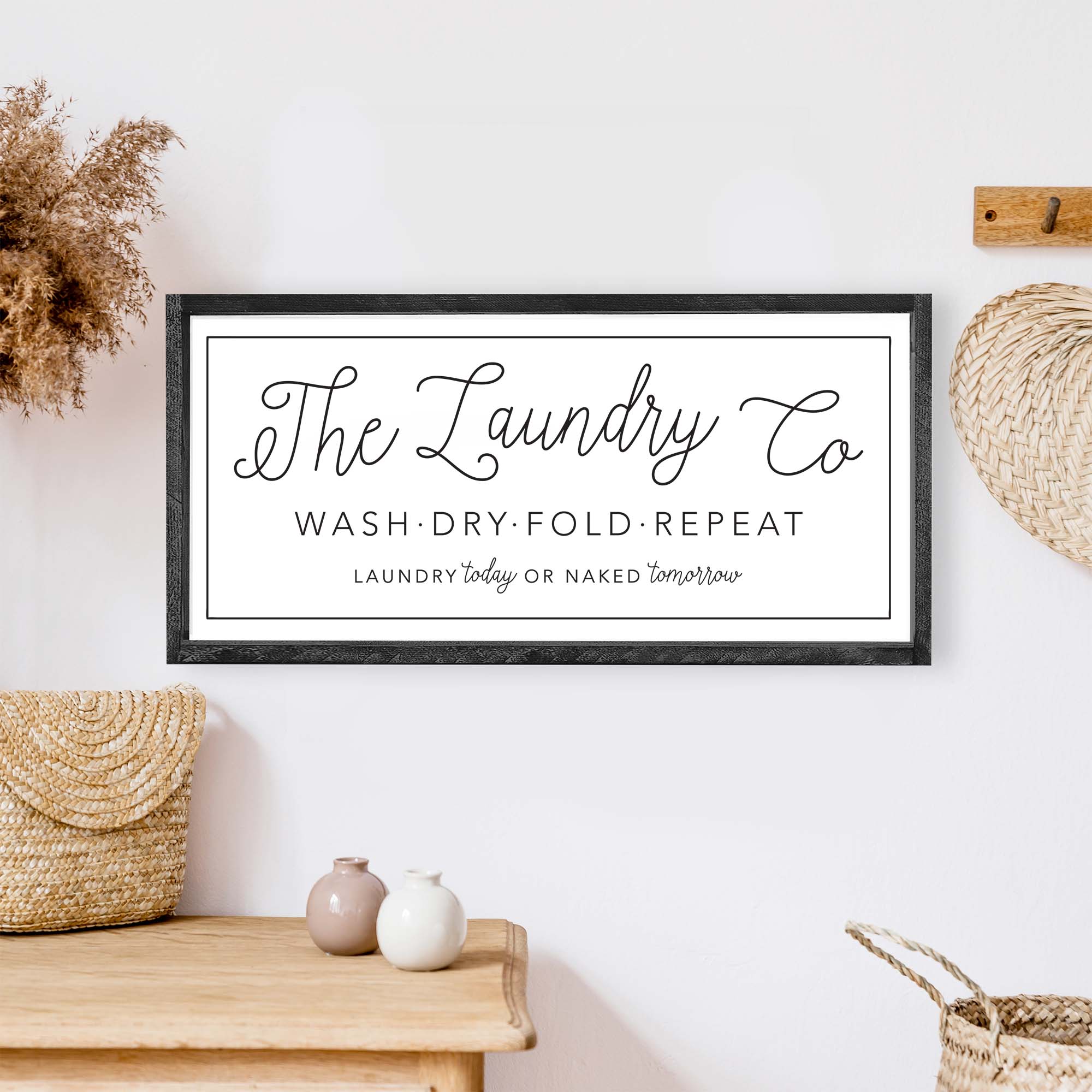 The Laundry Co Wood Sign featuring black and white text on a white background, framed in stained pine wood, perfect for laundry room decor.