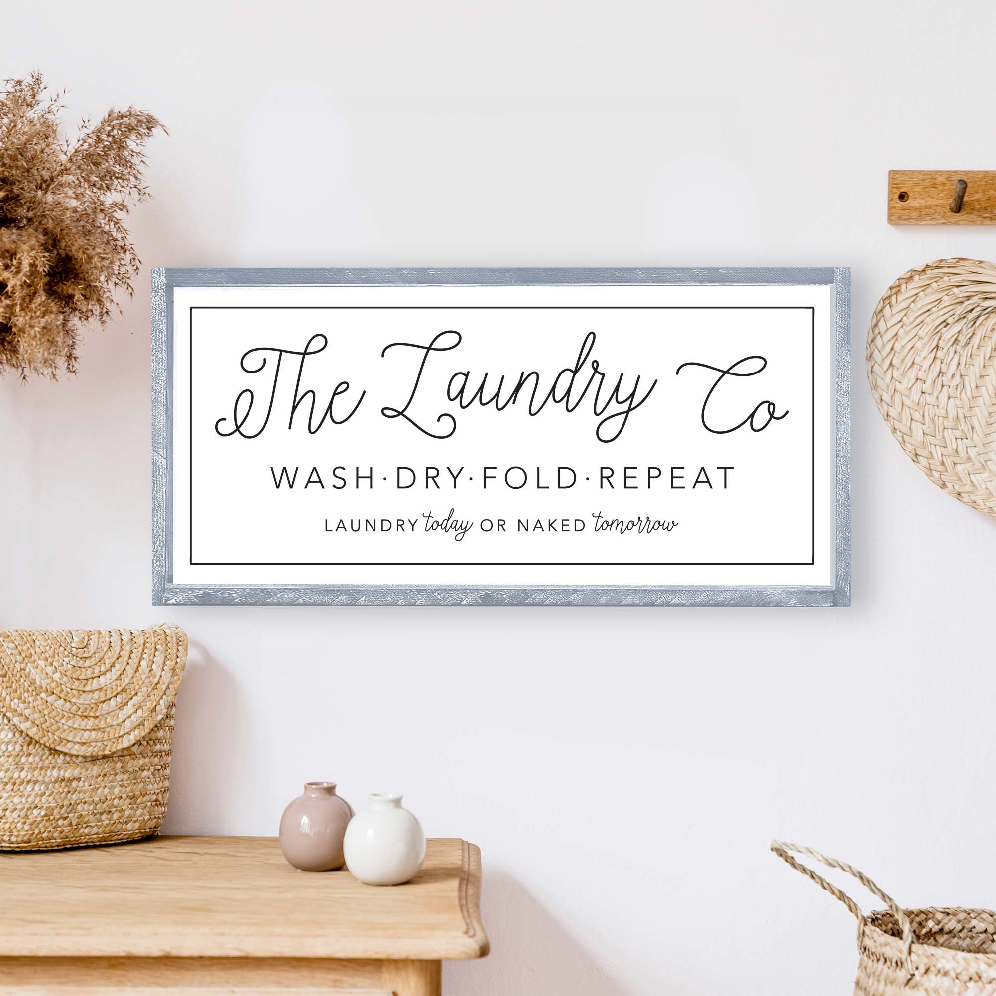 The Laundry Co Wood Sign featuring black and white text on a white background, framed in stained pine wood, perfect for laundry room decor.