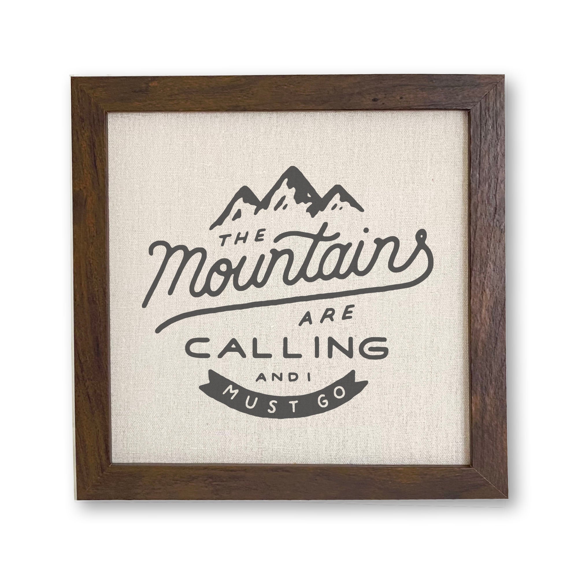 Framed sign featuring the phrase 'The Mountains are Calling' with a rustic wood frame and linen-look background.