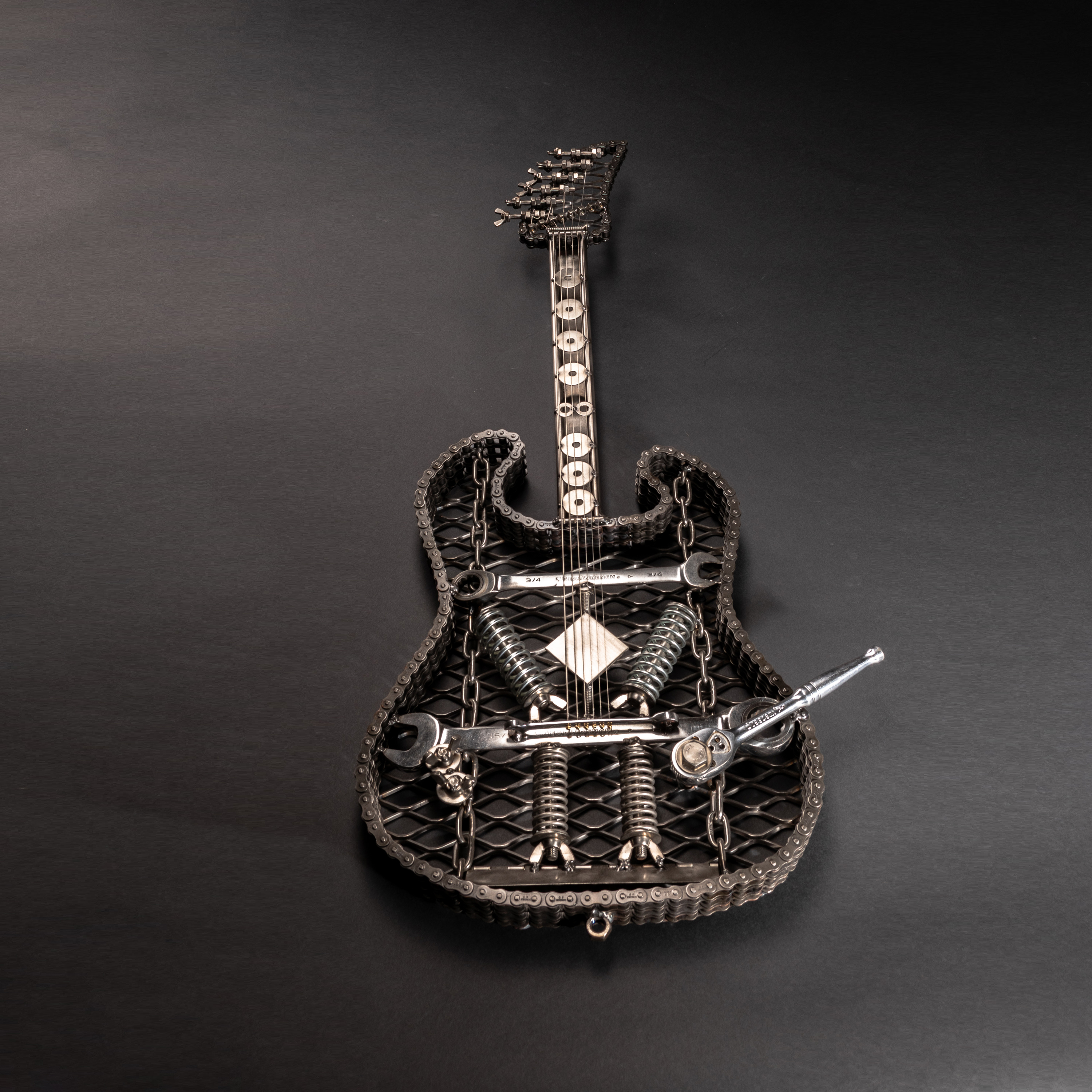 A handcrafted metal electric guitar sculpture, showcasing intricate details and a lifelike design, perfect for wall art enthusiasts.