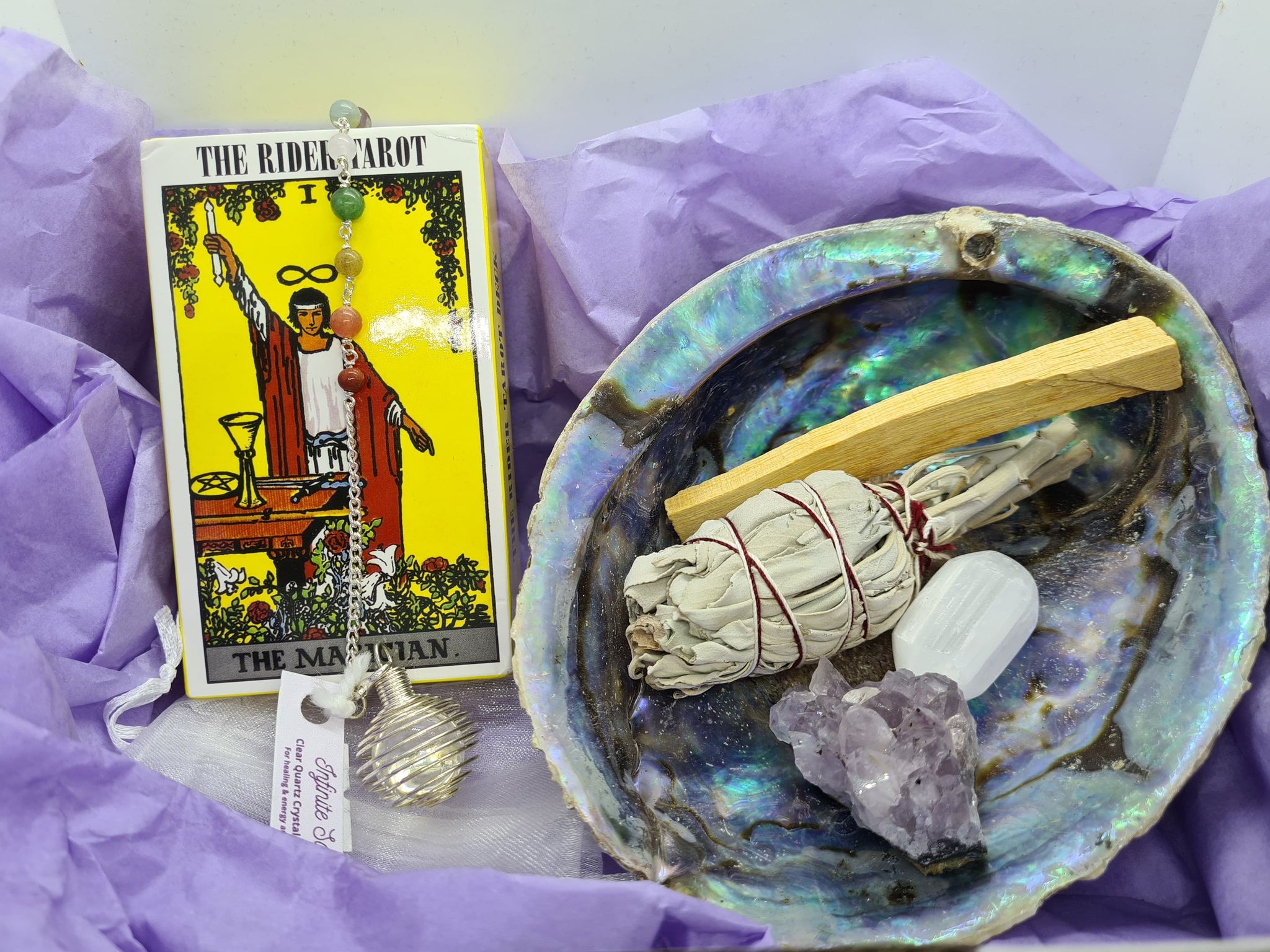 The Tarot Essentials Kit featuring a smudge kit, pendulum, and various tarot decks for spiritual growth and intuitive readings.