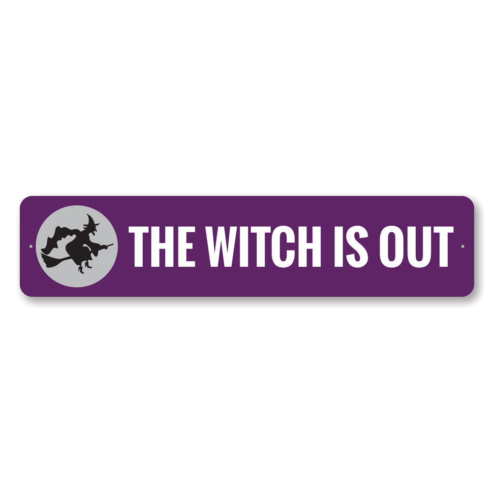 A decorative Halloween sign reading 'The Witch is OUT', made of high-quality aluminum, featuring spooky design elements.