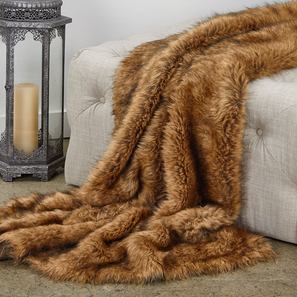 A luxurious tip dyed fox faux fur throw blanket in brown, showcasing its soft texture and reversible design.