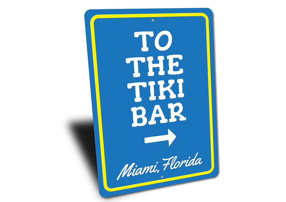 A decorative 'To the Tiki Bar' sign made of high-quality aluminum, featuring vibrant colors and a beach-themed design, perfect for coastal decor.