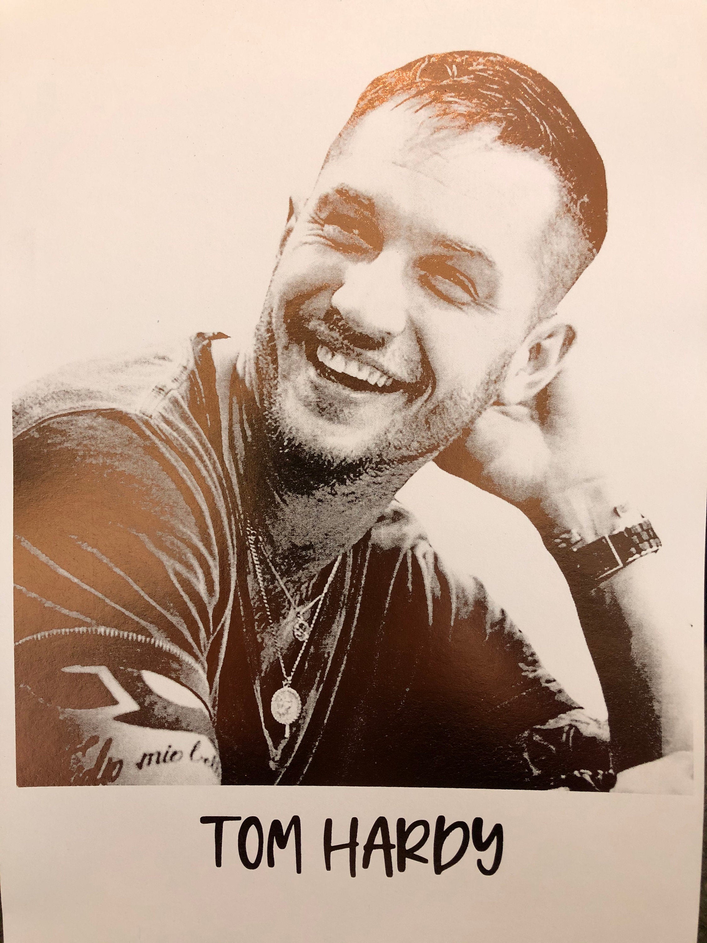 A beautiful foil print of Tom Hardy featuring a rose gold portrait on a white background.