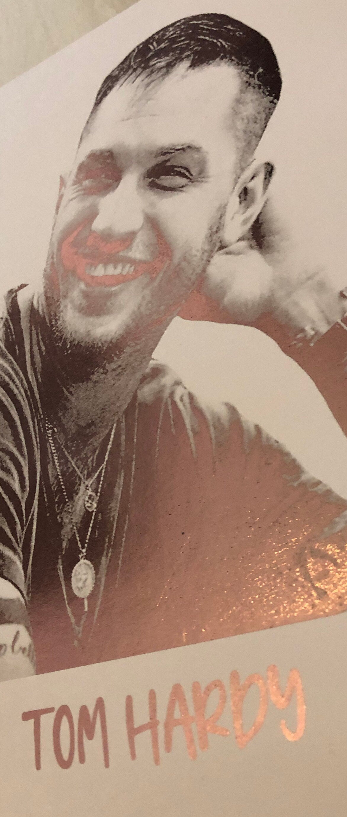 A beautiful foil print of Tom Hardy featuring a rose gold portrait on a white background.