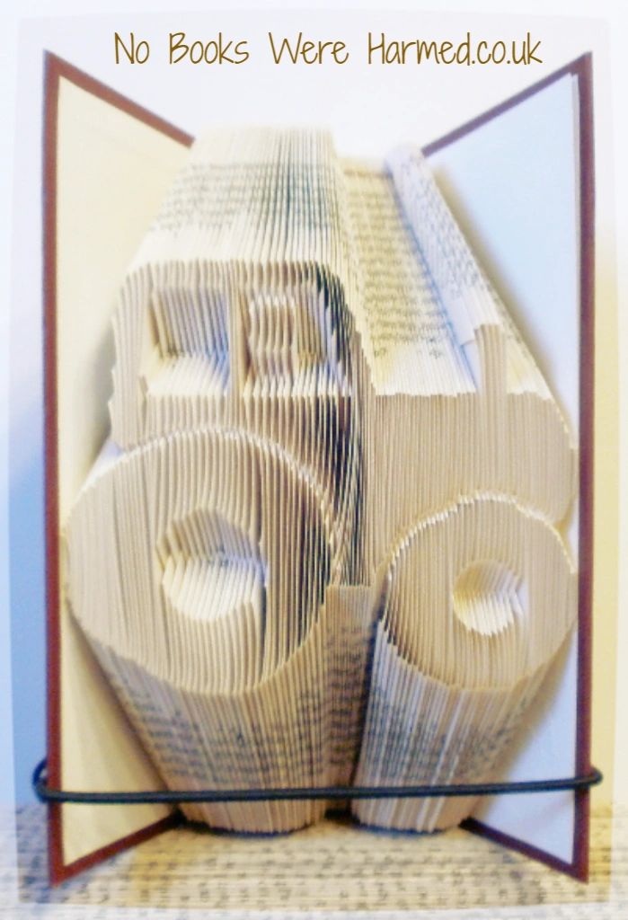 Hand-folded tractor art made from vintage books, showcasing intricate folds and unique colors.