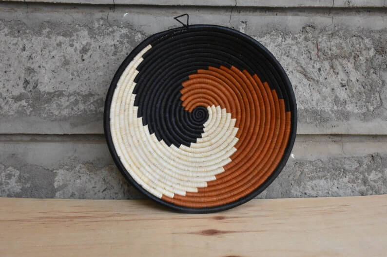 Traditional African Coiled Raffia Basket handcrafted from dyed raffia and banana stalks, featuring unique colors and patterns.