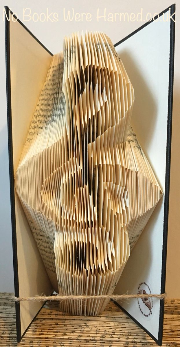 Handcrafted treble clef art made from vintage book pages, showcasing intricate folds and unique colors.