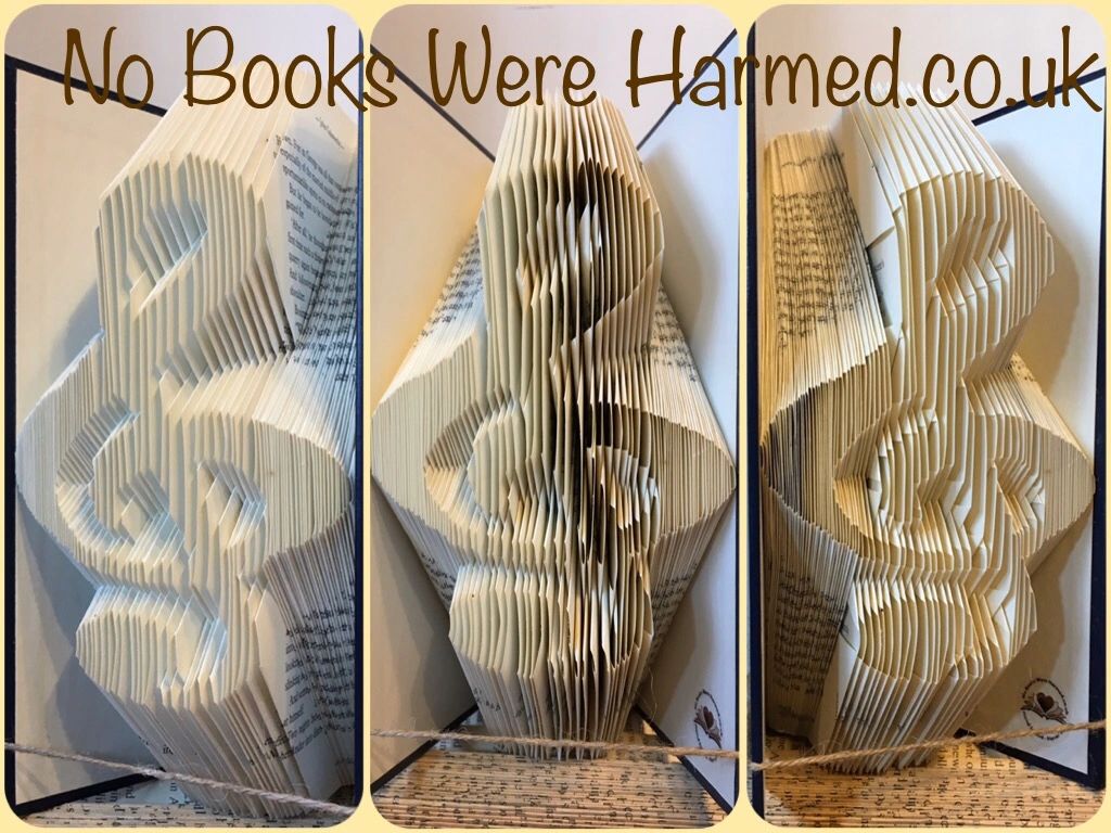 Handcrafted treble clef art made from vintage book pages, showcasing intricate folds and unique colors.