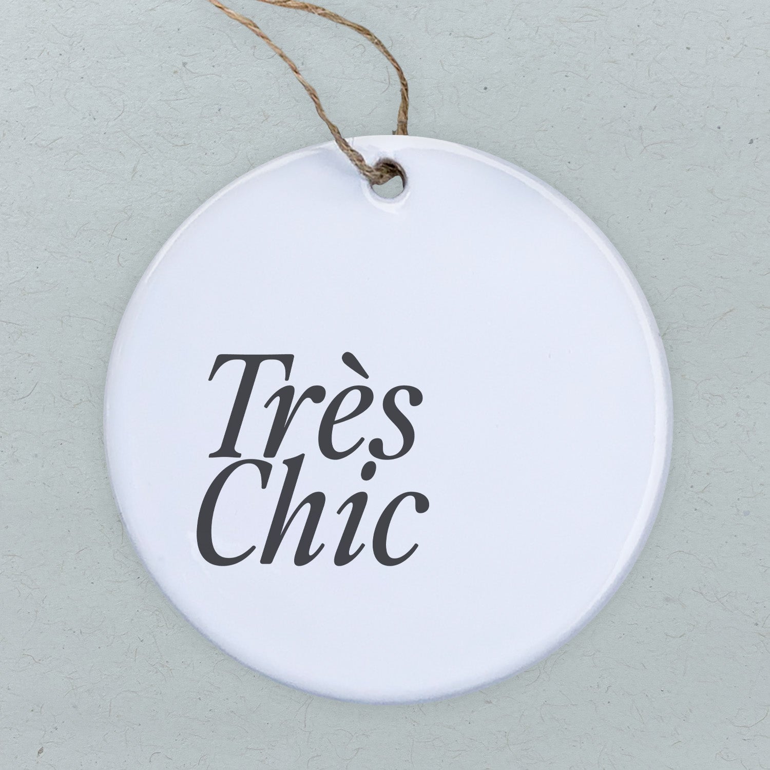 Tres Chic porcelain ornament featuring original designs, 2.75 inches in diameter with a smooth, glossy finish.