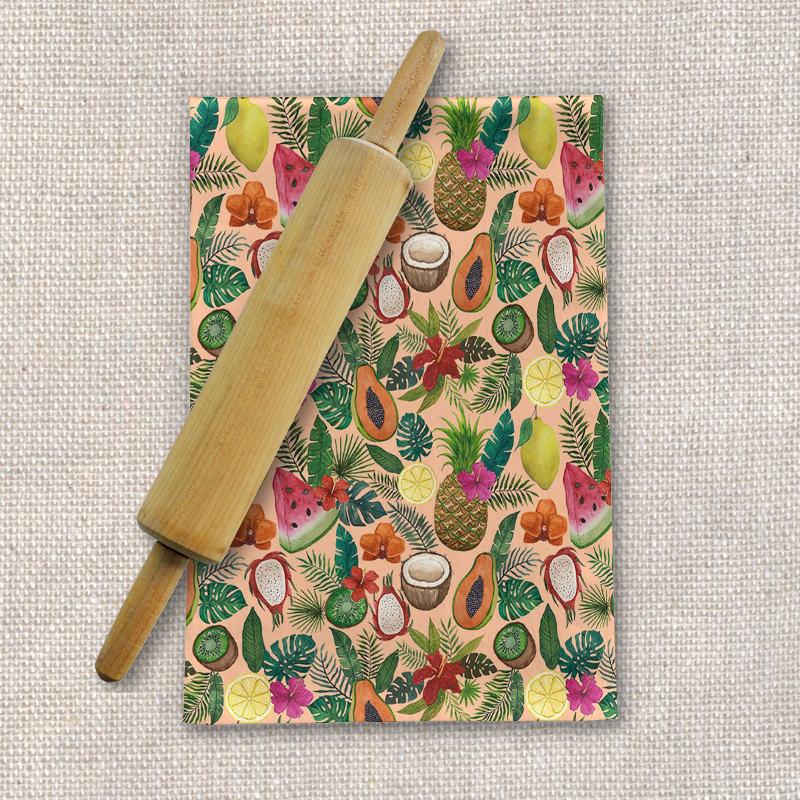 A colorful tea towel featuring tropical fruits and flowers, made of cotton twill, perfect for kitchen use.