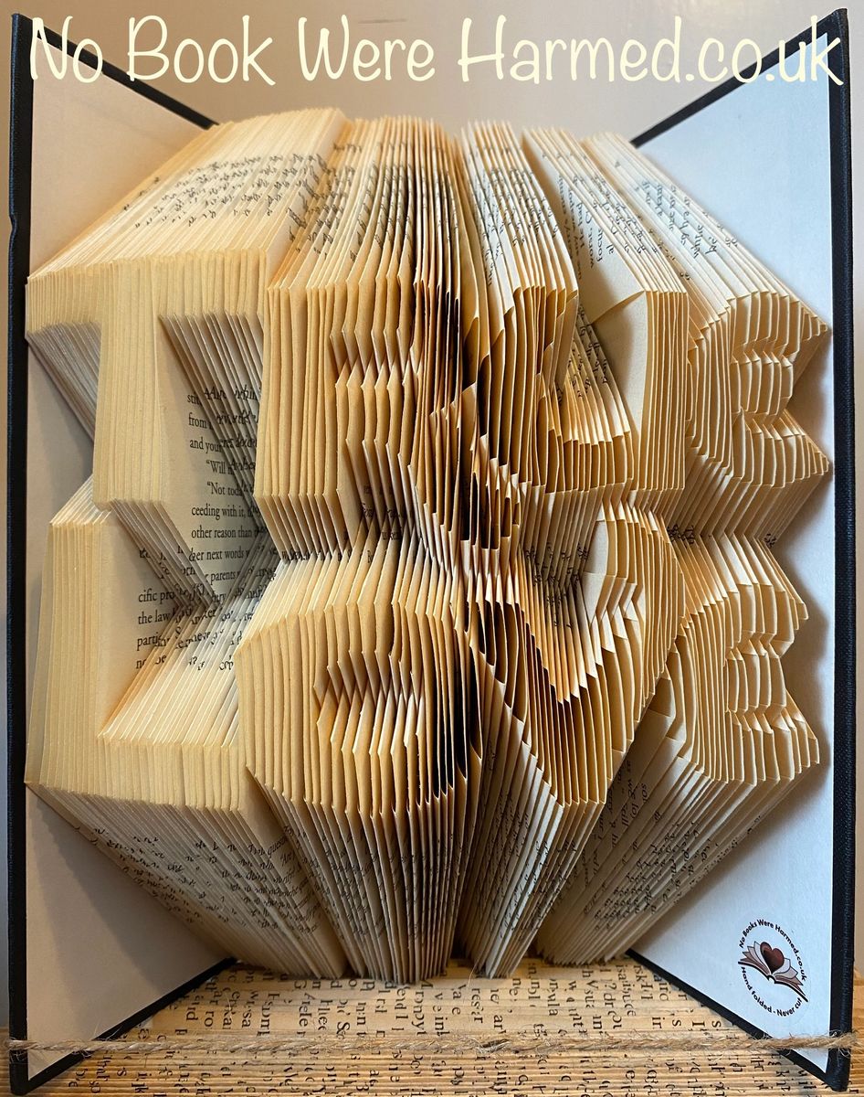 Handcrafted book art titled True Love, featuring intricately folded pages from vintage books, showcasing unique designs and textures.